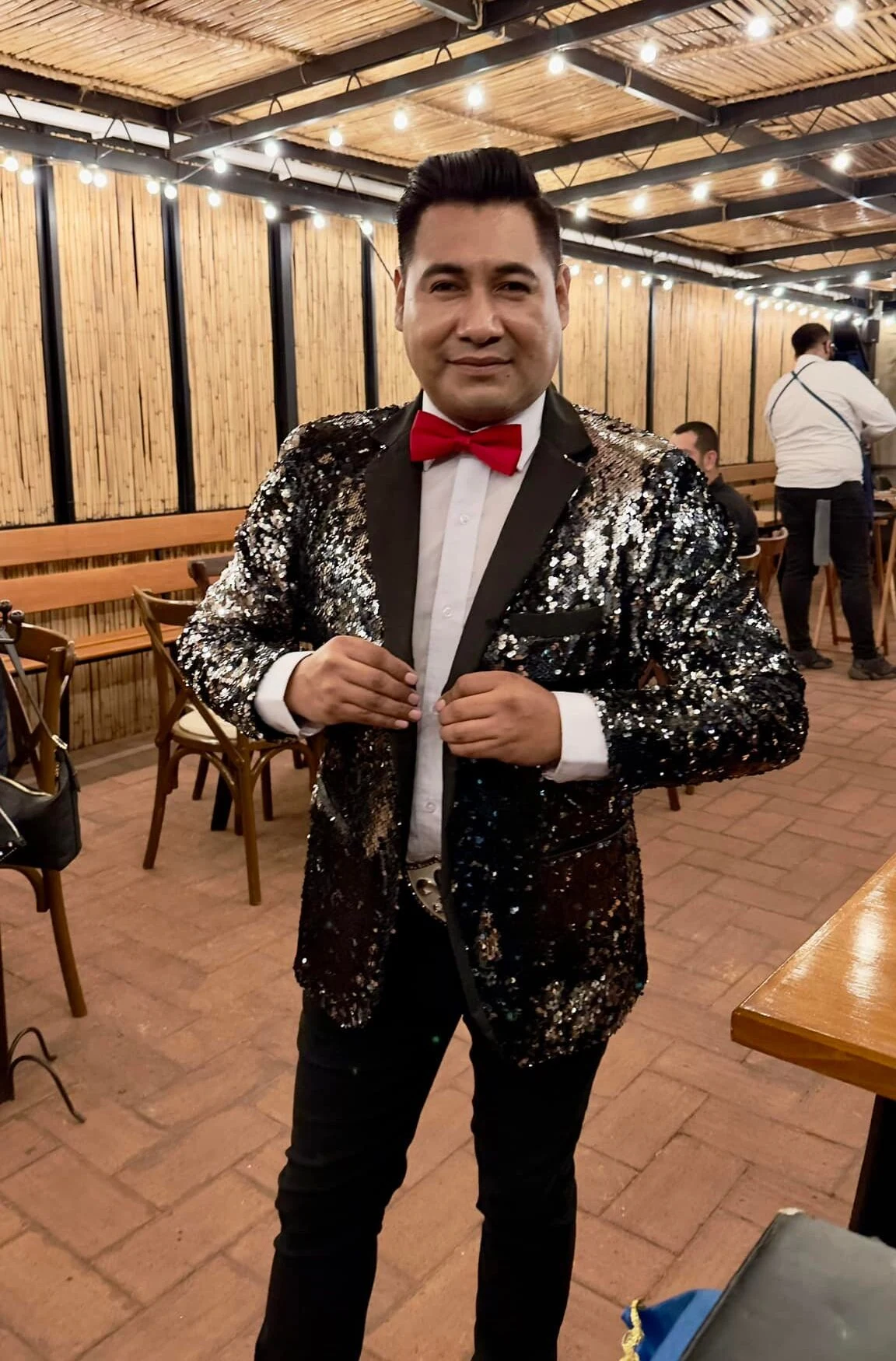 Mago Eikim de pie frente a un fondo de madera